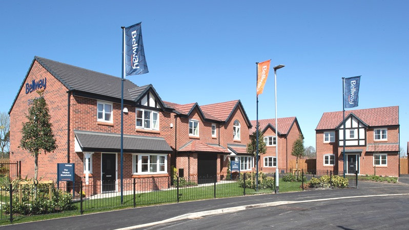 Bellway's houses are arranged in a lane with lovely flower bed and Ballway flags fluttering in front of houses.