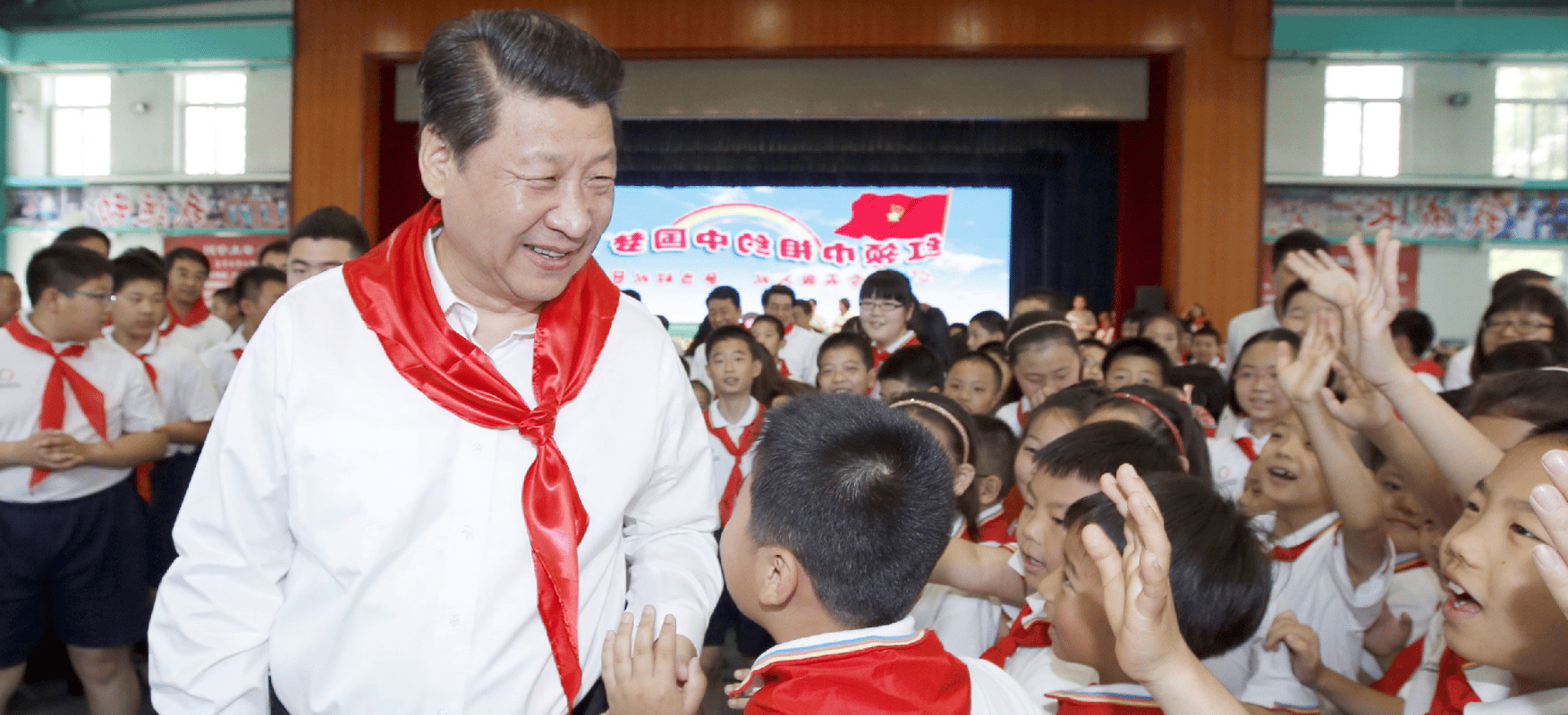 Chinese President Xi Jiping is being welcomed by a large number of students dressed in uniform.