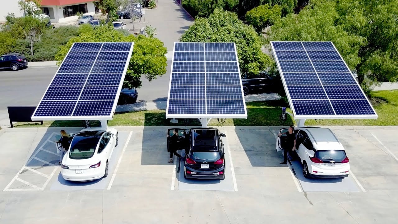 Three Beam Global solar tree EV chargers are planted in a lane, and three automobiles are availing the service