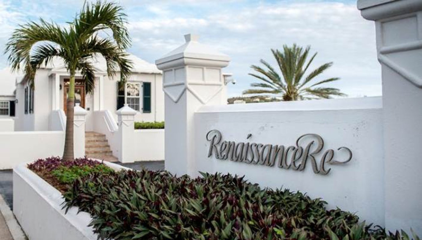 The Renaissance Re's White Painted Office is nestled in a tropical setting with palm trees and shrubs growing on the side.
