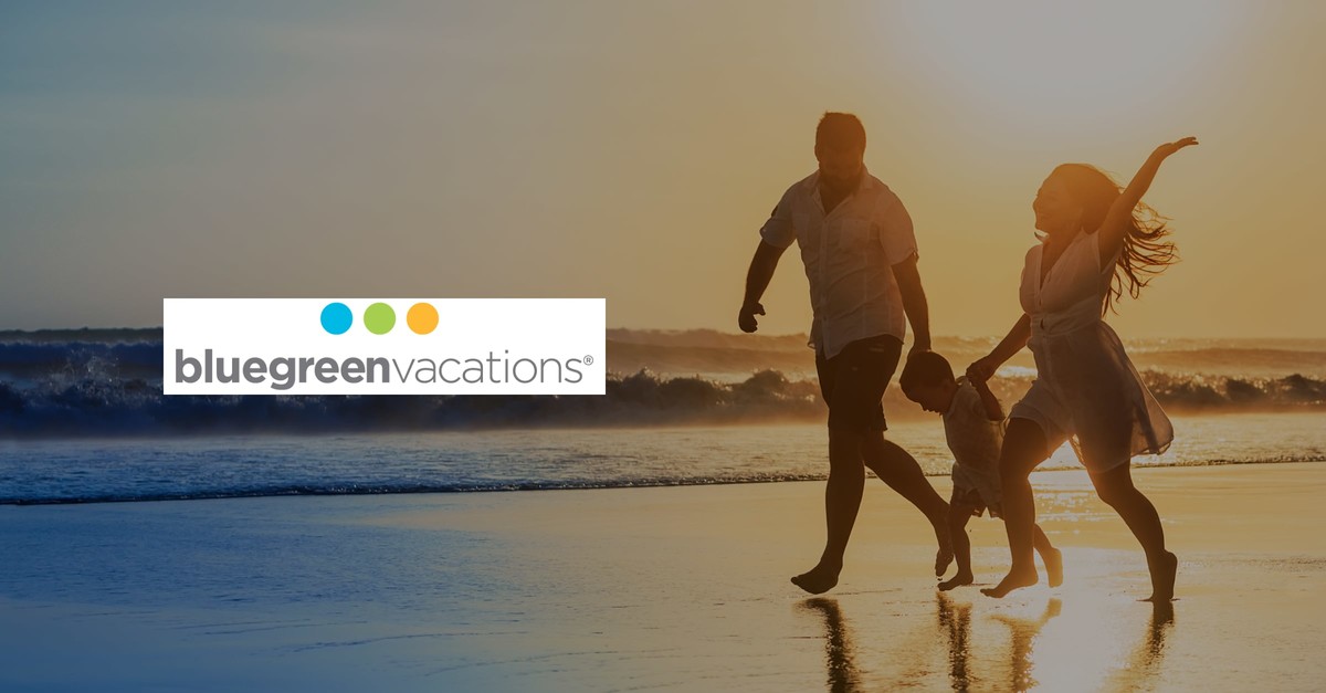 A girl and a boy with their child enjoy on the beach next to the sea, and the Bluegreen Vacation Holding Corp emblem is displayed.