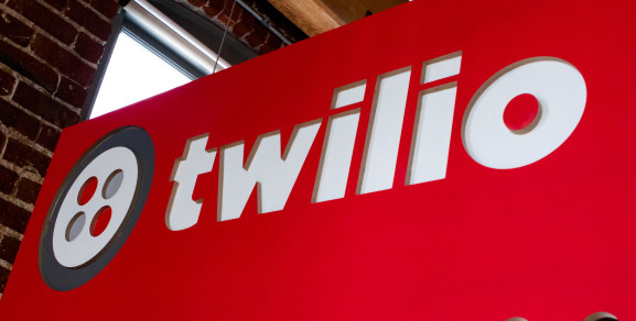 Twilio Inc's logo is displayed on a red board with a white and grey colour scheme.