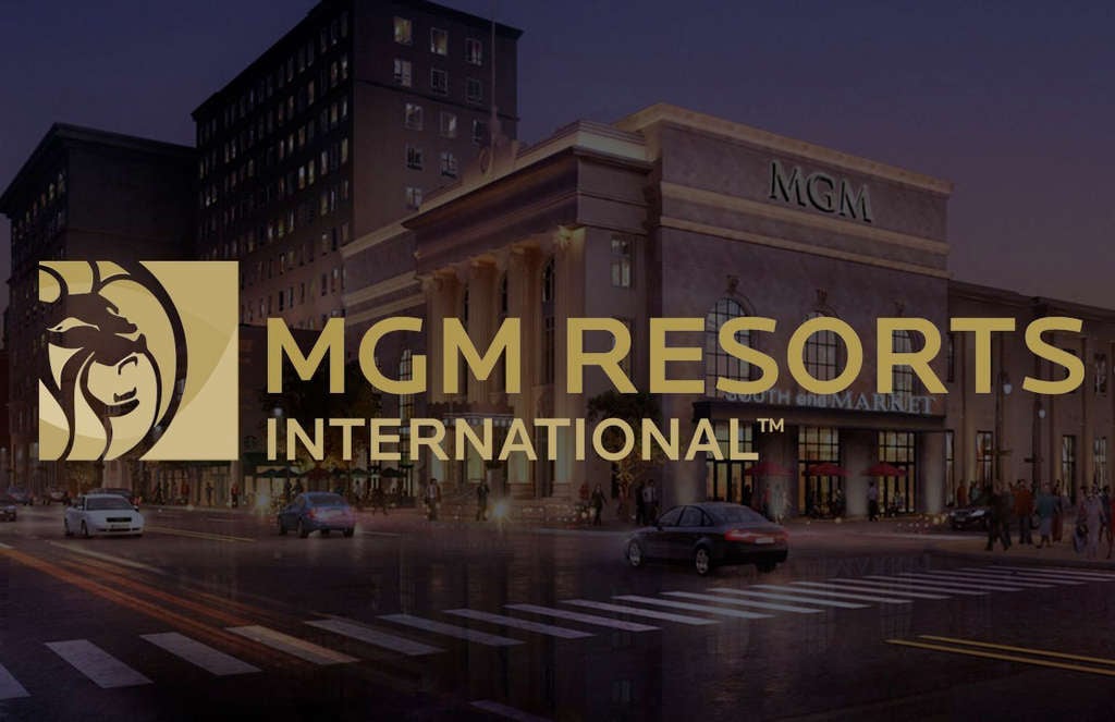 The MGM Resorts International Inc logo is presented on the image of a market corner where people are walking and traffic is heavy.